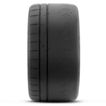 Close-up of a black car tire showing detailed tread grooves along the center and edges.